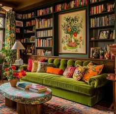 a living room filled with green couches and lots of books