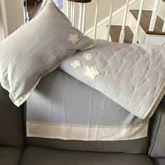 two pillows sitting on the back of a couch in front of a stair case and railing