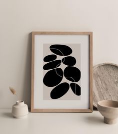 a black and white art print on a shelf next to a bowl