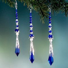 three pieces of blue glass hanging from a tree