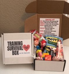 a box filled with candy sitting on top of a table next to a sign that says training survival box