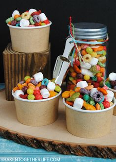 three cups filled with different types of candy