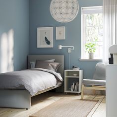 a bedroom with blue walls and white furniture