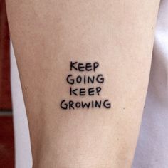 a person with a tattoo on their arm that says keep going keep growing in black ink