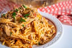 a white plate topped with pasta covered in sauce