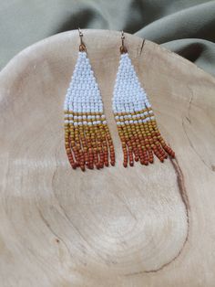 Handcrafted seed bead danglers; modeled after the snow dusted red rock in Sedona. White, mustard yellow, and rust with silver findings. Each pair is made with over 200 glass beads and woven with strong, braided thread. Approximately 2.25 inches long. Please care for your earrings, store them flat or hung when not being worn. Orange Jewelry With Tiny Beads For Crafting, Orange Dangling Beads For Jewelry Making, Unique White Beaded Earrings For Festival, Artisan White Dangling Beads, Adjustable Orange Tiny Beads Earrings, Artisan White Beaded Earrings With Tiny Beads, Artisan White Beaded Earrings With Dangling Beads, Artisan White Beaded Earrings, Artisan White Earrings With Tiny Beads