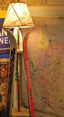 two skis and a lamp in front of a map on a table with a lamp shade