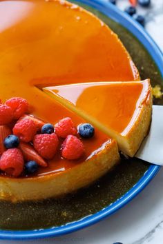 a cheesecake topped with berries and orange slices