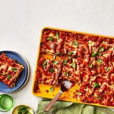 a pan filled with lasagna casserole on top of a green towel