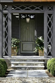 an image of a front door and steps with plants on either side in the photo