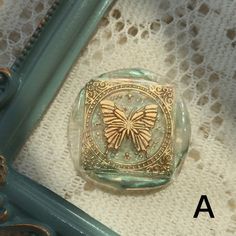 a glass box with a butterfly on it sitting on a table next to a lace doily