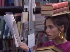 a woman with books on her head in a library