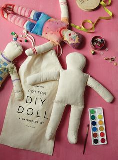 an assortment of crafting supplies laid out on a pink surface