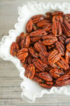 a white bowl filled with pecans sitting on top of a table