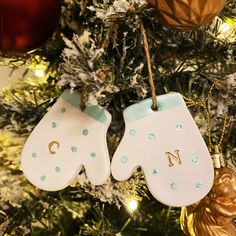 two white mittens hanging from a christmas tree