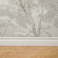 an empty room with a wallpapered tree in the corner and wood flooring