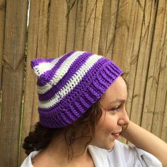 a woman wearing a purple and white knitted hat