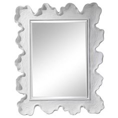 a white framed mirror sitting on top of a wall