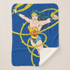 the wonder woman is depicted on this blue and yellow throw blanket with a white border