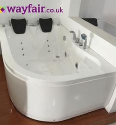 a white bath tub sitting on top of a wooden floor