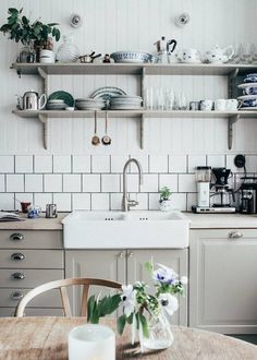 a kitchen filled with lots of white appliances and counter top next to a wooden table