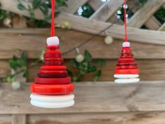 three red and white ornaments hanging from strings