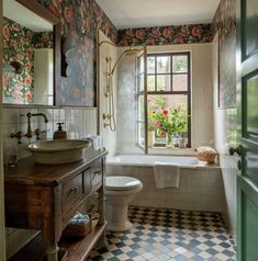 a bathroom with a checkered floor and floral wallpaper on the walls is shown