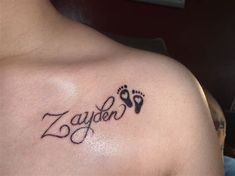 a man with a tattoo on his chest that says zayden and has footprints in it