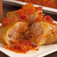 two stuffed cabbages with meat and tomato sauce on a white plate