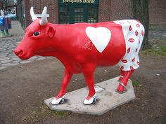 a statue of a red cow with white hearts on it's body