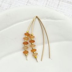 Indulge in luxury with our Wish - Orange Aventurine & Gold earrings. Handcrafted with golden threads and shimmering orange aventurine gemstones, these earrings add a touch of sophistication to any outfit. The perfect accessory to match Pantone's 2024 color of the year, Peach Fuzz. 14k Gold Filled wire Natural Orange Aventurine Gemstones Approximately 1.5" long Includes Silicone Backing Nut Sent in a Ribboned Gift Box with Polishing Cloth Handmade in Montana Orange Aventurine, 2024 Color, African Turquoise, Peach Fuzz, Color Of The Year, Jewelry Packaging, Christmas Shopping, Montana, Gold Earrings