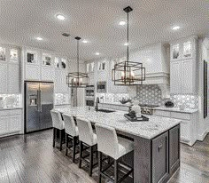 a large kitchen with white cabinets and marble counter tops