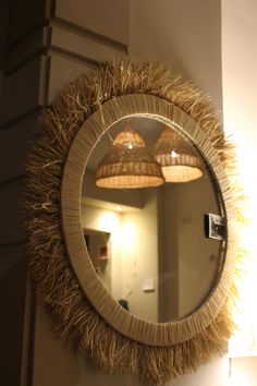 a mirror that has some lights on it in front of a wall with two lamps