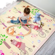 a little boy playing with toys on the floor in front of a rug that has animals and trees on it