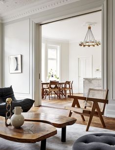 a living room filled with furniture and a wooden coffee table in front of a doorway