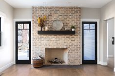 an empty living room with a brick fireplace