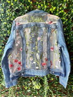 an old jean jacket with flowers on it