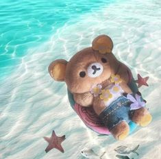 a brown teddy bear sitting on top of a raft in the ocean next to fish