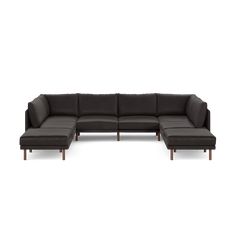 a black leather sectional sofa with chaise lounger and footstools on an isolated white background