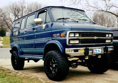 the blue van is parked on the side of the road in front of another vehicle