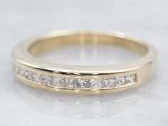 a yellow gold wedding band with princess cut diamonds