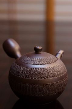 a brown tea pot sitting on top of a wooden table