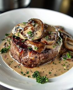 a white plate topped with meat covered in mushroom gravy and garnished with parsley