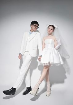 a man and woman dressed in white posing for the camera