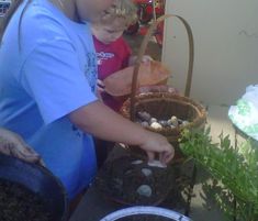 a woman and child are looking at plants