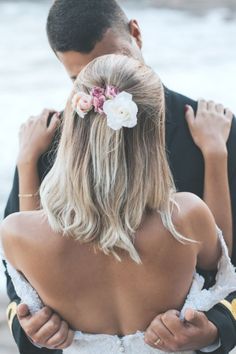 the back of a bride's dress as she holds her grooms arm around him