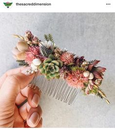 a person is holding a comb with flowers and leaves on it, while the comb has been placed in front of them