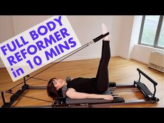 a woman laying on top of an exercise machine with a sign reading full body reformer in 10 mins