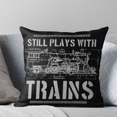 a black and white throw pillow with the words still plays with trains on it's side