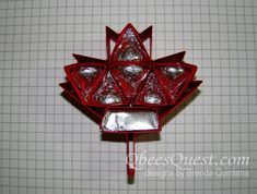 a piece of red glass sitting on top of a white table next to a wall